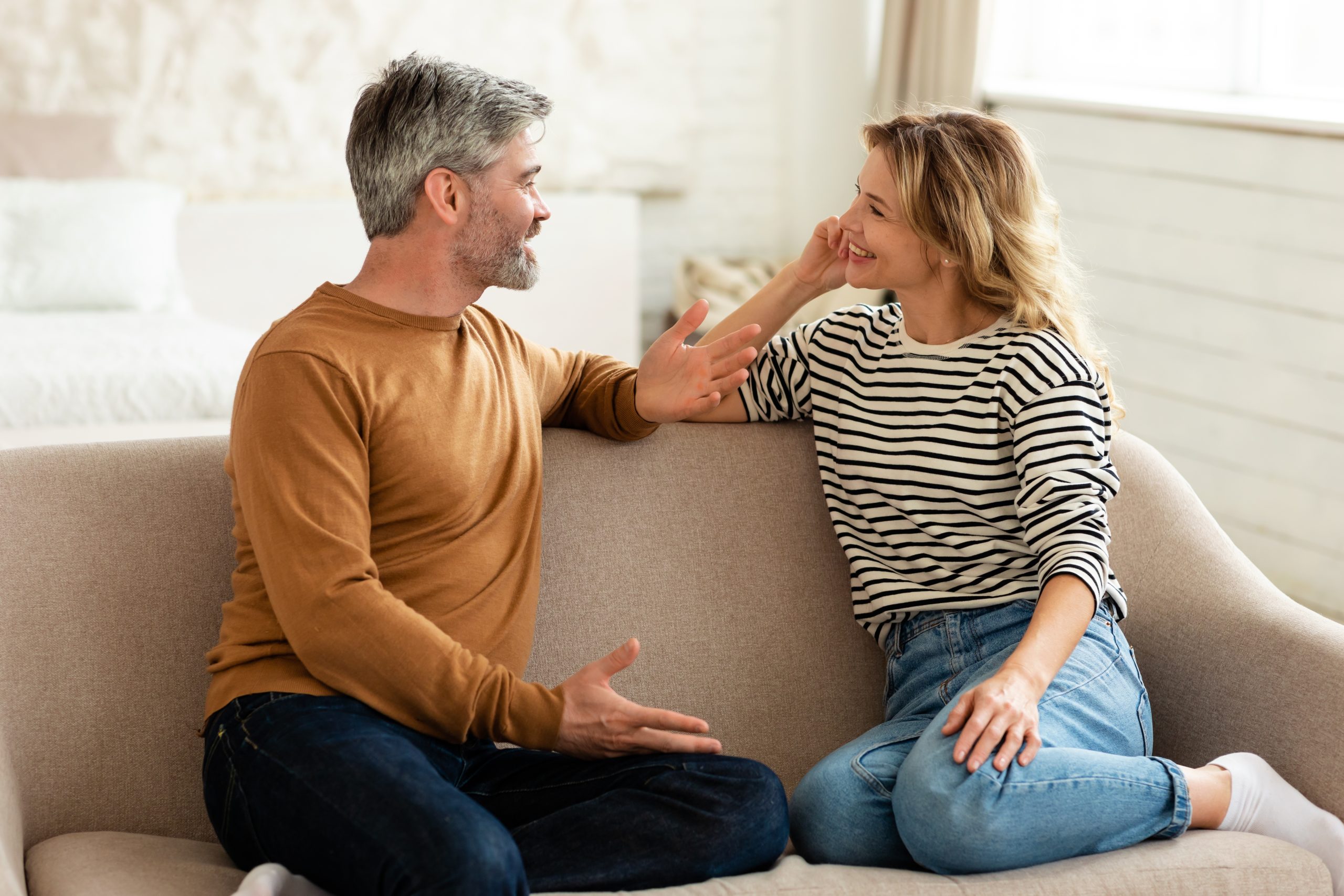 Hoe je van conflict naar rust in je relatie komt: Man en vrouw die samen zitten te praten op de bank